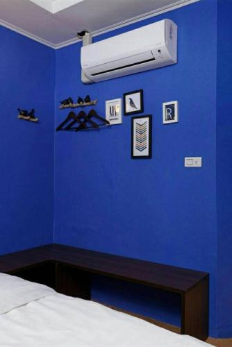 a blue bedroom with a bed and a blue wall at At Tainan Inn in Tainan