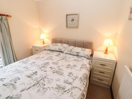 a bedroom with a bed and two night stands at Lavender Cottage in Richmond
