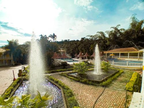 a couple of fountains in front of a pool at Hotel Villa San Cayetano in Nocaima