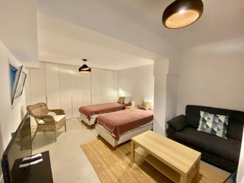 a hotel room with a bed and a couch and a couch at Bohemian Blue Villa - 7 BDRM - beach in 200m - MG Villas in Panormos Mykonos