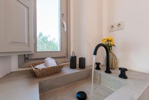 a kitchen sink with a faucet and a basket on the counter at Bohemian Blue Villa - 7 BDRM - beach in 200m - MG Villas in Panormos Mykonos