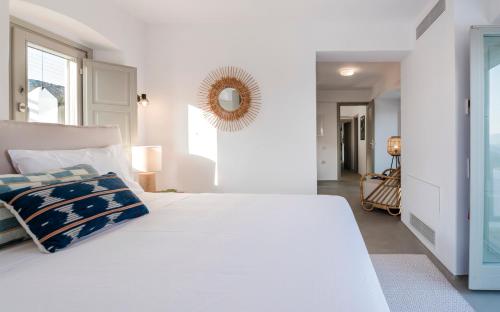 a white bedroom with a large white bed and a mirror at Bohemian Blue Villa - 7 BDRM - beach in 200m - MG Villas in Panormos Mykonos
