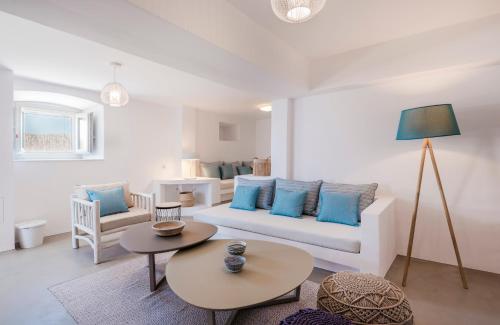 a living room with a white couch and blue pillows at Bohemian Blue Villa - 7 BDRM - beach in 200m - MG Villas in Panormos Mykonos