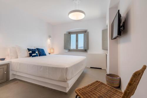 a white bedroom with a bed and a tv at Bohemian Blue Villa - 7 BDRM - beach in 200m - MG Villas in Panormos Mykonos