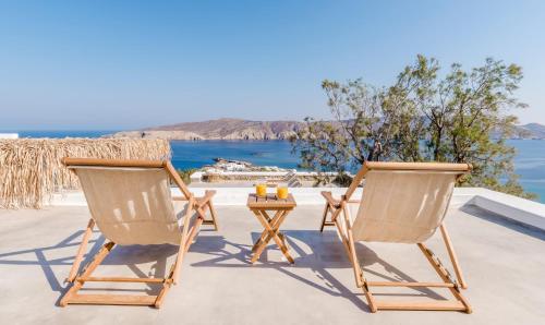 two chairs and a table on a patio with the ocean at Bohemian Blue Villa - 7 BDRM - beach in 200m - MG Villas in Panormos Mykonos