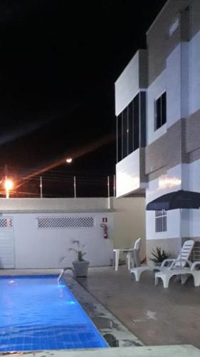 a swimming pool in front of a building at night at FLAT RIOMAR in Coruripe