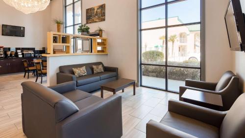 a living room with two couches and a table at SureStay Plus Hotel by Best Western Hammond in Hammond