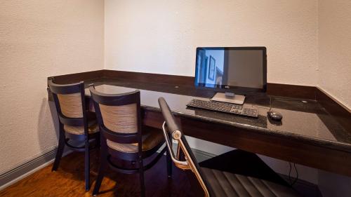 a desk with a computer monitor and a keyboard at SureStay Plus Hotel by Best Western Hammond in Hammond