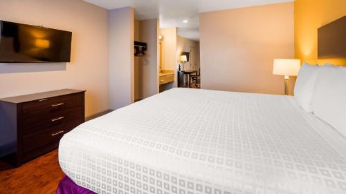 a bedroom with a large white bed and a television at SureStay Plus Hotel by Best Western Hammond in Hammond