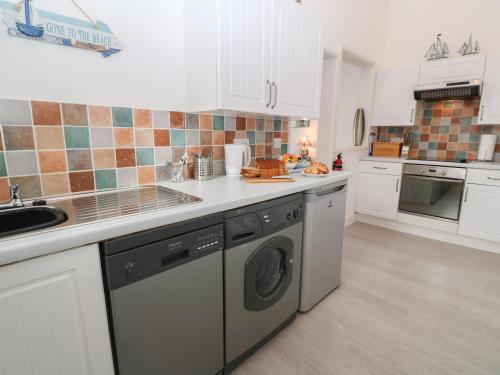 a kitchen with a washer and a dishwasher at Beachcomber in Marazion