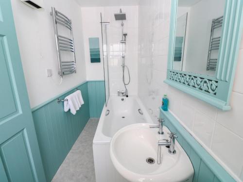 a bathroom with a sink and a bath tub at Beachcomber in Marazion