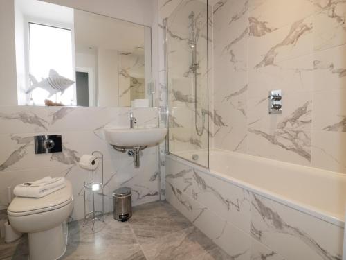 a bathroom with a toilet and a sink and a shower at The Sand Dunes in Crantock