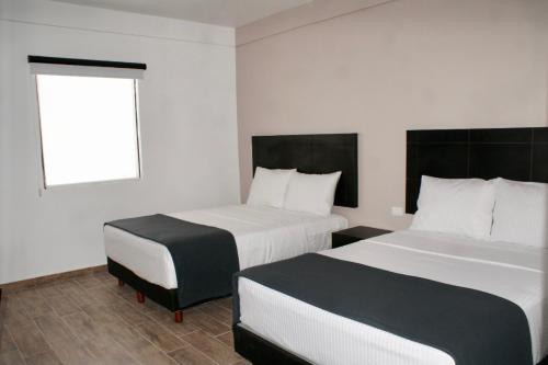 Habitación de hotel con 2 camas y ventana en Hotel Capital Frontera en Monclova