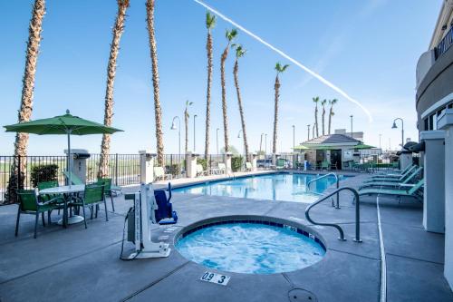 - une piscine avec des palmiers dans un complexe dans l'établissement Holiday Inn Express Hotel & Suites Yuma, an IHG Hotel, à Yuma