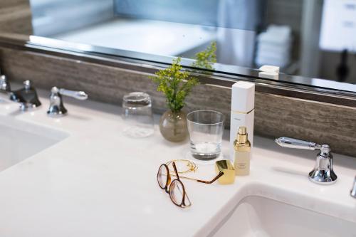 a bathroom sink with glasses and a mirror at Hotel Bel-Air - Dorchester Collection in Los Angeles