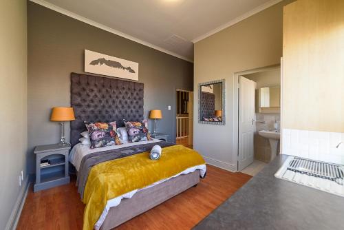 a bedroom with a large bed and a bathroom at Leeuwenzee Guesthouse in Cape Town