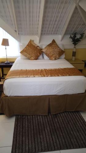 a bedroom with a large bed with white sheets and pillows at Poolside Mystic Apt 9A in Ocho Rios