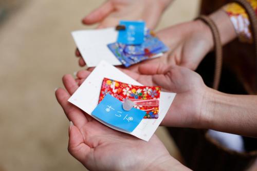 a person holding up cards in their hands at Matsunoyu in Matsue