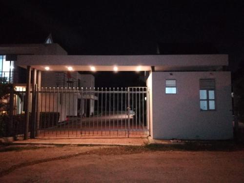 uma casa com um portão à noite com luzes em Casa Campestre, exclusiva para ti y tu Familia em Ricaurte