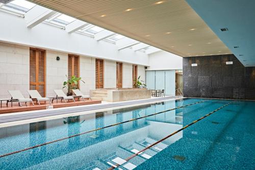 a large swimming pool with chairs and a pool at Oakwood Premier Coex Center in Seoul