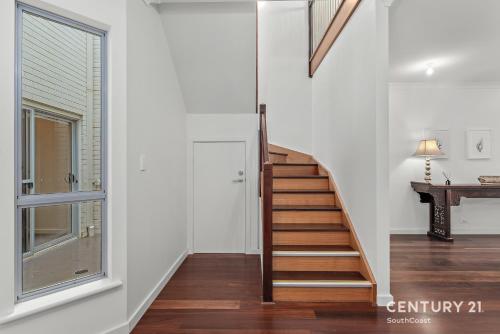 a staircase in a white room with a window at Percival Point - Port Willunga - C21 SouthCoast Holidays in Port Willunga