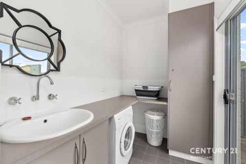 a bathroom with a sink and a washing machine at Percival Point - Port Willunga - C21 SouthCoast Holidays in Port Willunga