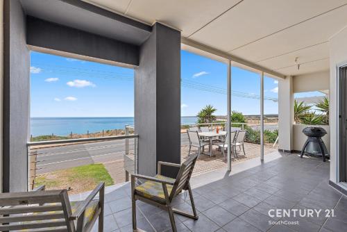 a balcony with a table and chairs and the ocean at Percival Point - Port Willunga - C21 SouthCoast Holidays in Port Willunga
