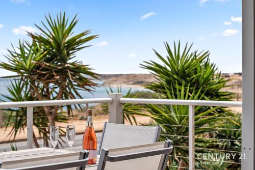 a table with two chairs and a bottle of champagne at Percival Point - Port Willunga - C21 SouthCoast Holidays in Port Willunga