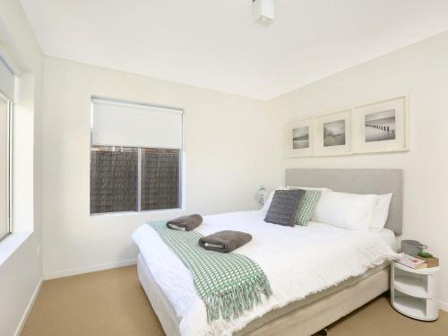 - une chambre blanche avec un lit et une fenêtre dans l'établissement Isthmus on North Kiama Drive, à Kiama Downs