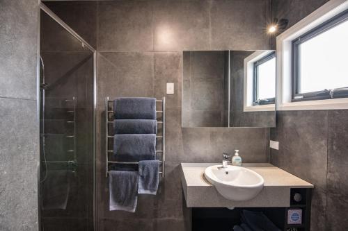 La salle de bains est pourvue d'un lavabo et d'une douche. dans l'établissement Manna Hill Farm, à West Kentish