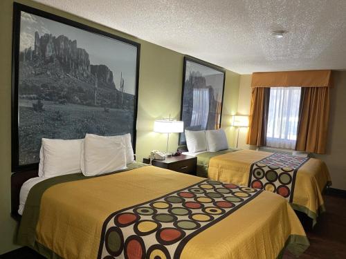 a hotel room with two beds and a painting on the wall at Super 8 by Wyndham Casa Grande in Casa Grande