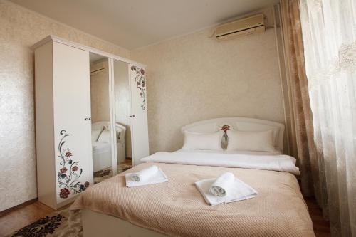 een slaapkamer met een bed met handdoeken erop bij Квартира на Пушкина in Alma-Ata