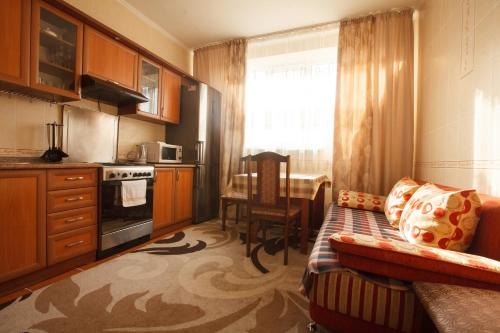 a kitchen with a couch and a table and a window at Квартира на Пушкина in Almaty