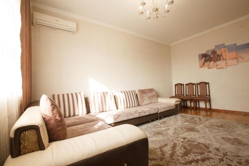 uma sala de estar com um sofá e uma mesa em Квартира на Пушкина em Almaty