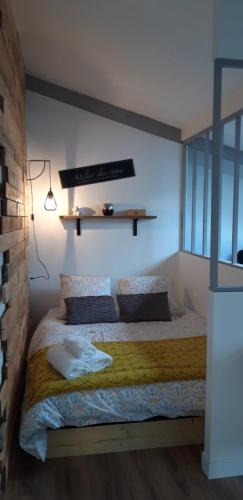 a bedroom with a bed with a shelf on the wall at studio de jack in Le Mesnil-Esnard