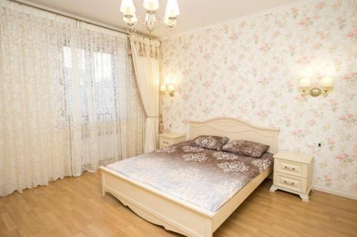 a bedroom with a bed in a room with pink wallpaper at Provence Deribasivska Apartment in Odesa