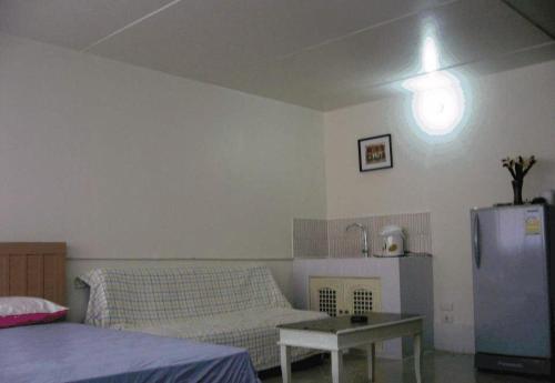 a living room with a couch and a table at Poppular Palace Don Mueang Bangkok in Bangkok