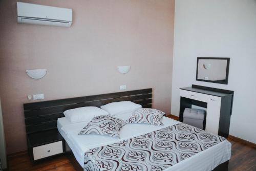 1 dormitorio con 1 cama con sábanas y almohadas blancas en Sayanogorsk Hotel, en Sayanogorsk