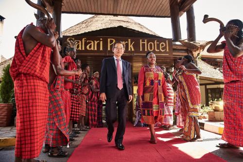 a man in a suit walking down a red carpet at Safari Park Hotel in Nairobi