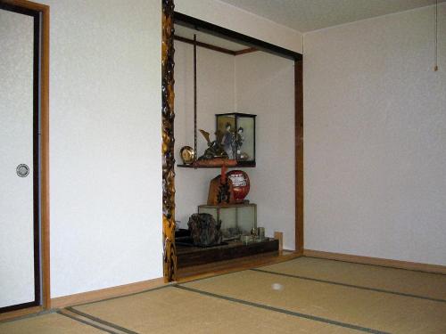 a room with a mirror and a shelf with items at Minshuku Mutsukari in Furano