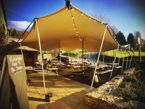 a large tent with tables and chairs under it at The Crown Inn in Rodmarton