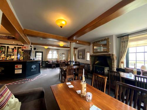 een restaurant met een tafel en stoelen en een bar bij The Royal Oak in Ashbourne