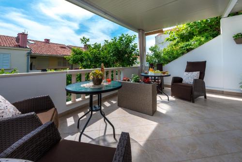 Un patio con sillas y una mesa en el balcón. en Guest House Kuna, en Dubrovnik