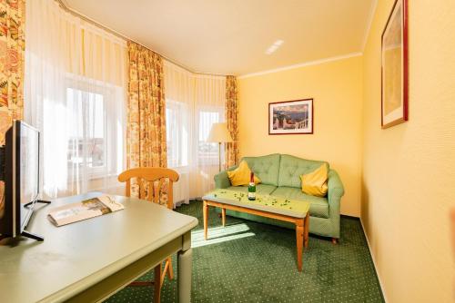 a living room with a couch and a table at Hotel Herzog Georg in Bad Liebenstein