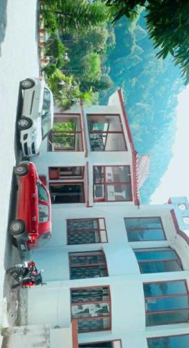 a red bus parked on the side of a building at Vamoose Sachin International in Rudraprayāg