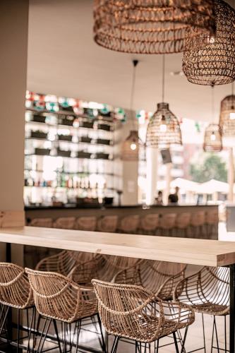 a bar with rattan chairs and a wooden table at Sunny Beach Club - Adults Only #YouthfulVibes in Sunny Beach