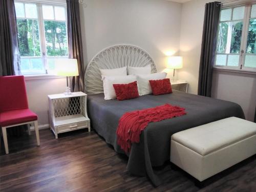 a bedroom with a large bed with a red blanket at Keillor Lodge in Maleny