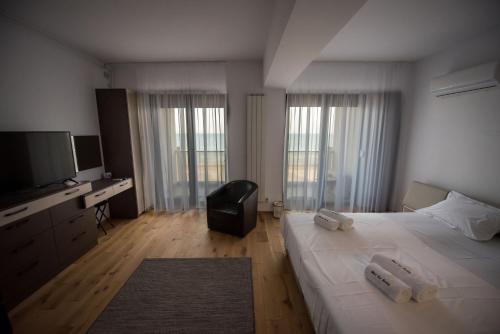 een slaapkamer met een groot bed en een flatscreen-tv bij Black Sea Booking - Munchen in Mamaia Nord – Năvodari