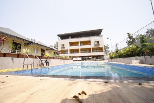 a swimming pool in front of a building at Indradhanush Hill Resort in Mulshi