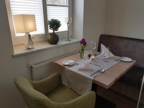 a dining room table with a white table cloth and chairs at Ringhotel Villa Margarete in Waren